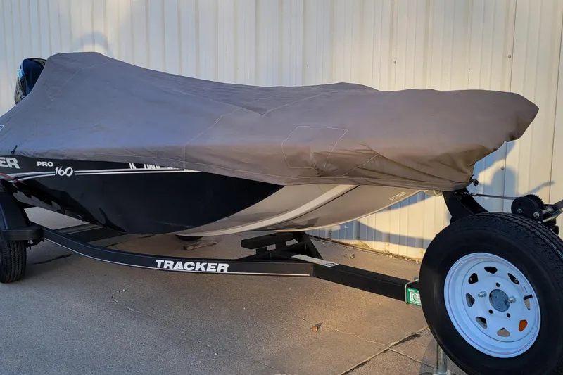 Slide: The Image of 2018 Bass Tracker Pro 16 boat covered, on trailer, parked outdoors. - 3