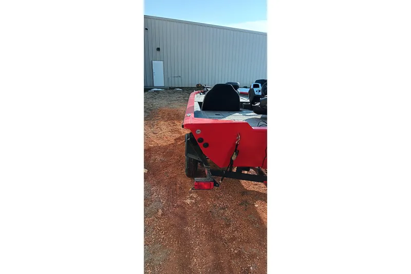 Slide: The Image of 2026 Tracker Pro Team 175 boat, red exterior, parked outdoors near a building. - 12