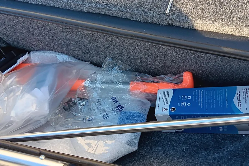 Slide: The Image of Storage compartment of 2026 Tracker Pro Team 175 boat with various items. - 16