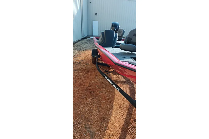 Slide: The Image of 2026 Tracker Pro Team 175 boat, red exterior, parked on gravel near a building. - 4