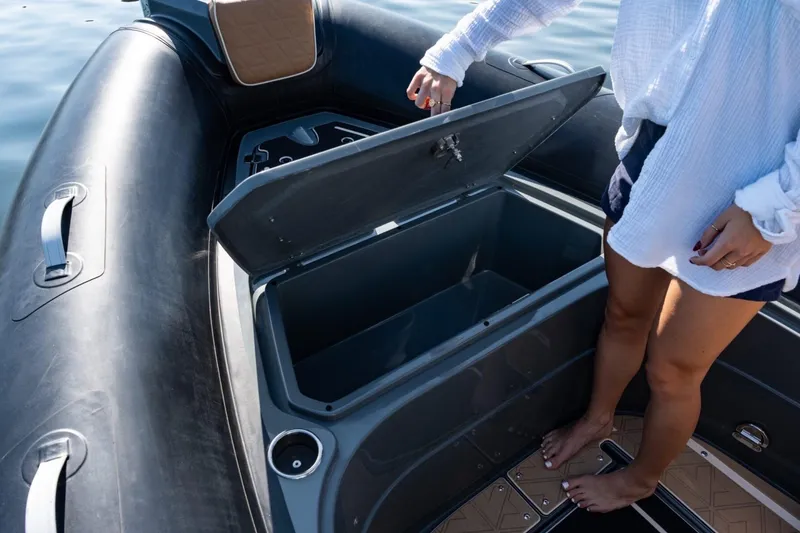 Slide: The Image of Person opening storage compartment on 2026 Highfield Escape 650 boat. - 11