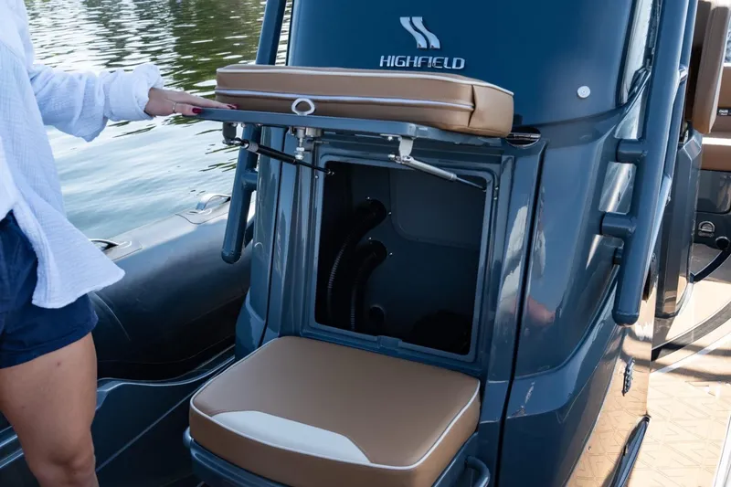 Slide: The Image of 2026 Highfield Escape 650 boat interior with storage compartment open on the water. - 12