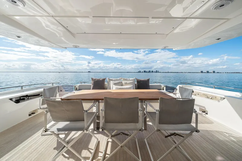 Slide: The Image of Luxurious 2018 Ferretti Yachts 850 deck with dining area overlooking serene ocean view. - 76
