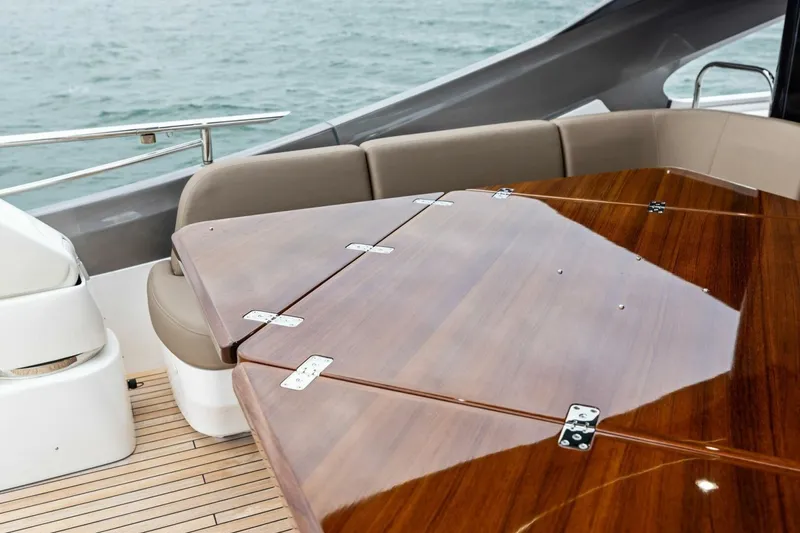 Slide: The Image of Luxurious 2024 Princess X80 yacht interior with polished wooden table and cushioned seating. - 106