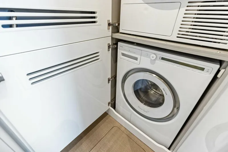 Slide: The Image of Compact laundry area with a modern washing machine in a 2024 Princess X80 yacht. - 130