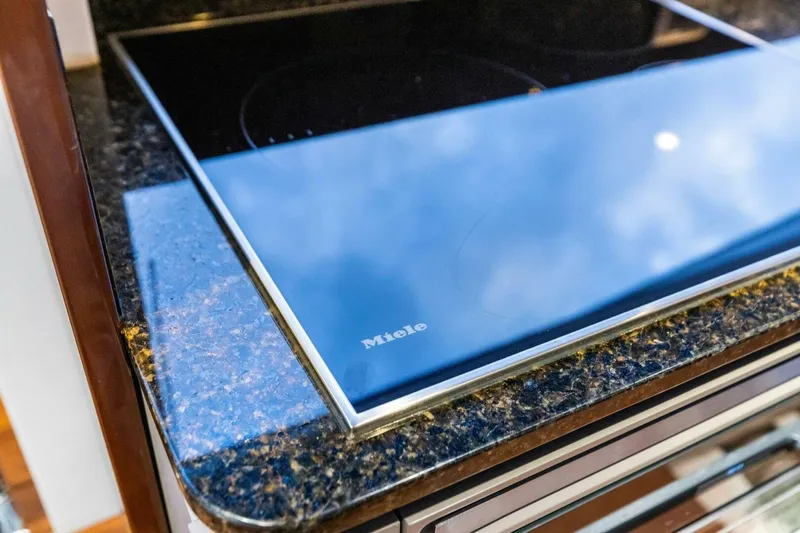 Slide: The Image of Modern Miele cooktop on granite countertop in 2024 Princess X80 yacht kitchen. - 34