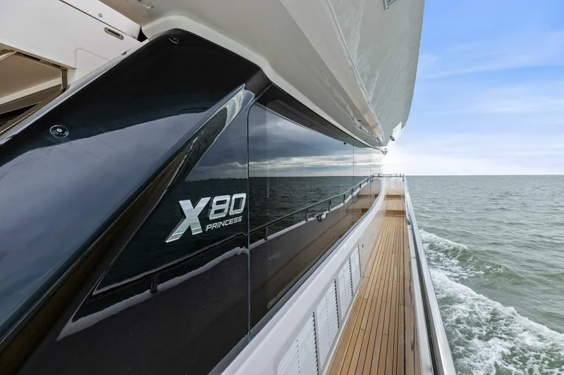 Slide: The Image of 2024 Princess X80 yacht cruising on open sea with sleek design and wooden deck. - 86