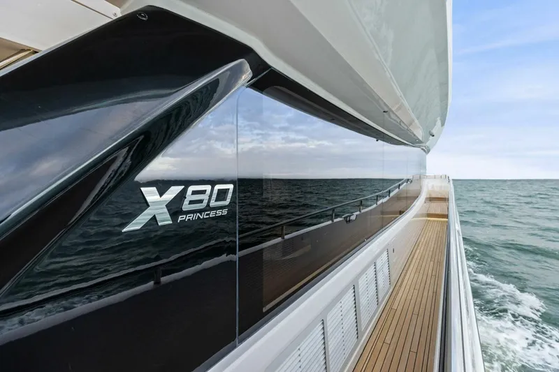 Slide: The Image of 2024 Princess X80 yacht cruising on open sea with sleek design and wooden deck. - 93
