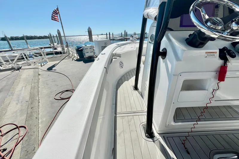 Slide: The Image of 2016 Sportsman Masters 247 Bay Boat interior with beige seating, docked by the water. - 15
