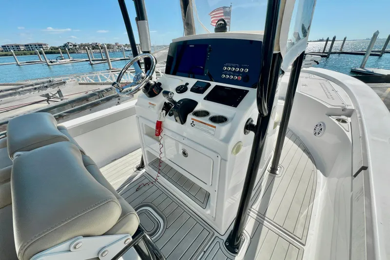 Slide: The Image of 2016 Sportsman Masters 247 Bay Boat at marina, featuring T-top and console cover. - 18