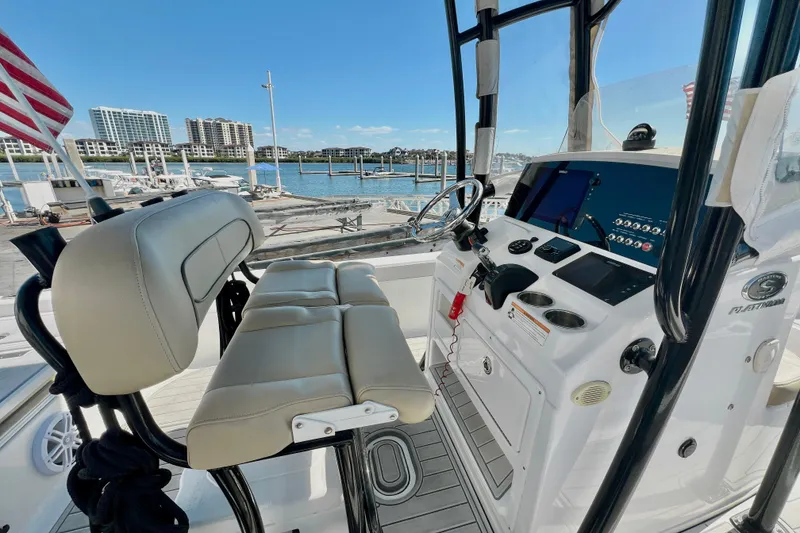 Slide: The Image of 2016 Sportsman Masters 247 Bay Boat interior with helm, seating, and marina view. - 2