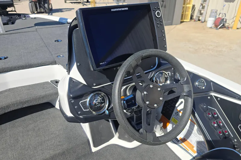 Slide: The Image of 2023 Skeeter ZXR19 boat dashboard with steering wheel and Humminbird Helix 12 display. - 12