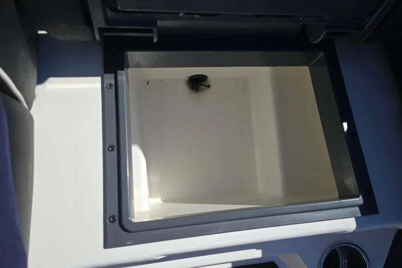 Slide: The Image of 2023 Skeeter ZXR19 boat storage compartment, open and empty, with a drain plug. - 14