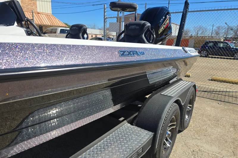 Slide: The Image of 2023 Skeeter ZXR19 boat on trailer, metallic finish, parked outdoors. - 23