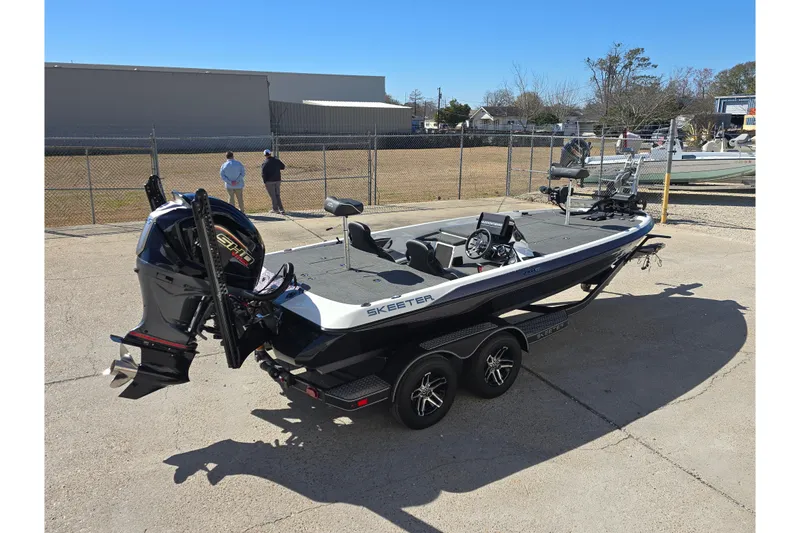 Slide: The Image of 2023 Skeeter ZXR19 boat with powerful engine, parked outdoors on a sunny day. - 4