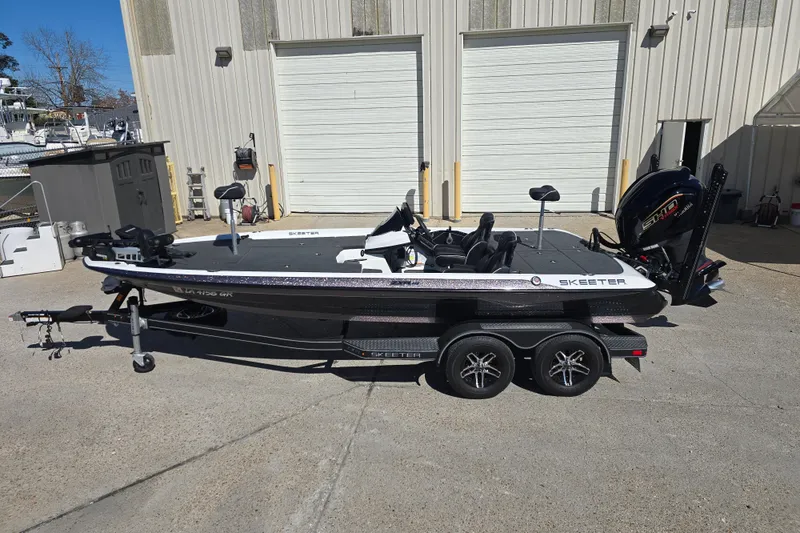 Slide: The Image of 2023 Skeeter ZXR19 fishing boat on trailer, parked outside industrial building. - 7