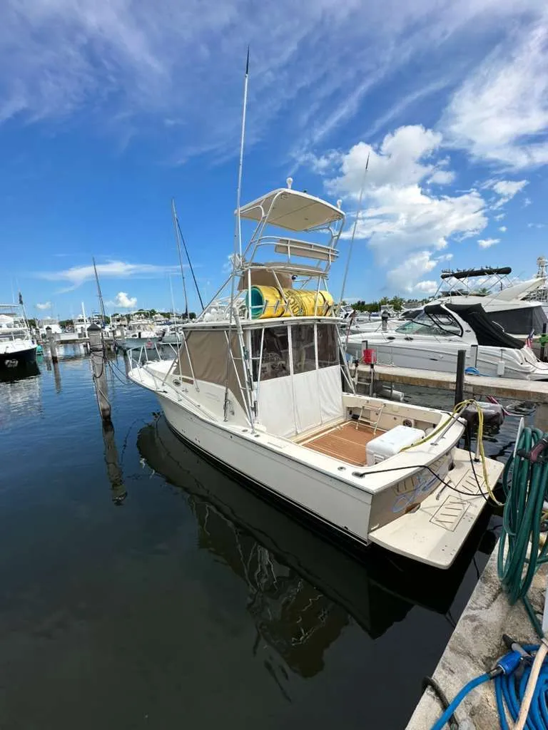 Slide: The Image of 1988 Atlantic 34 Express boat docked in marina under blue sky. - 2