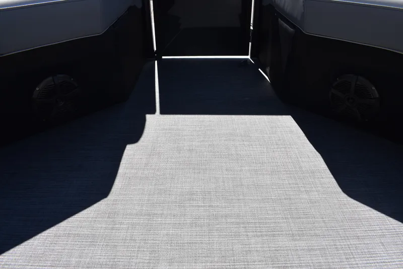Slide: The Image of Interior view of 2026 Lowe SS 230 WT boat with carpeted flooring and speakers. - 23