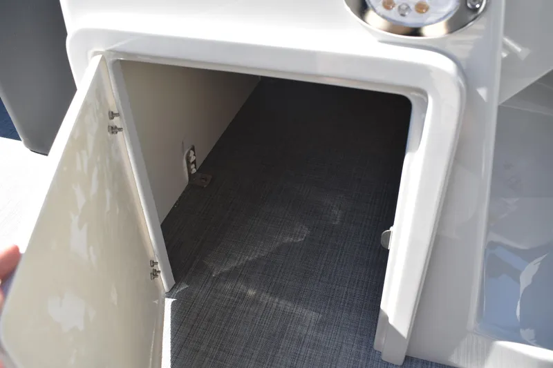 Slide: The Image of Open storage compartment on 2026 Lowe SS 230 WT boat, featuring carpeted interior. - 30