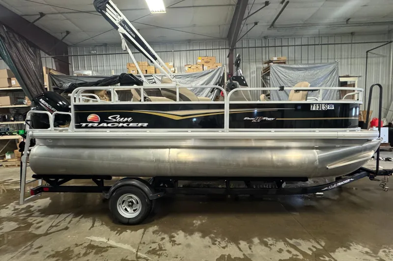 Slide: The Image of 2022 Sun Tracker Bass Buggy 18 DLX pontoon boat in indoor storage. - 3