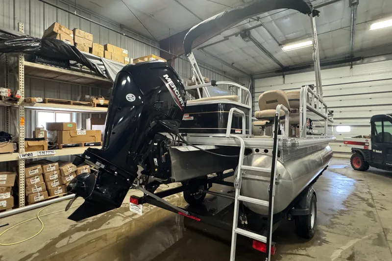 Slide: The Image of 2022 Sun Tracker Bass Buggy 18 DLX pontoon boat in a warehouse setting. - 4