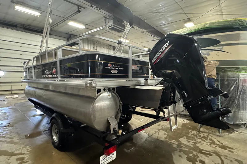 Slide: The Image of 2022 Sun Tracker Bass Buggy 18 DLX pontoon boat with Mercury outboard motor in a garage. - 5