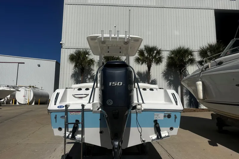 Slide: The Image of 2015 Sea Hunt Ultra 211 boat with 150 horsepower engine, parked outdoors. - 2