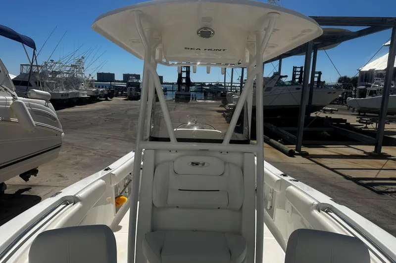 Slide: The Image of 2015 Sea Hunt Ultra 211 boat docked, showcasing interior seating and helm station. - 9