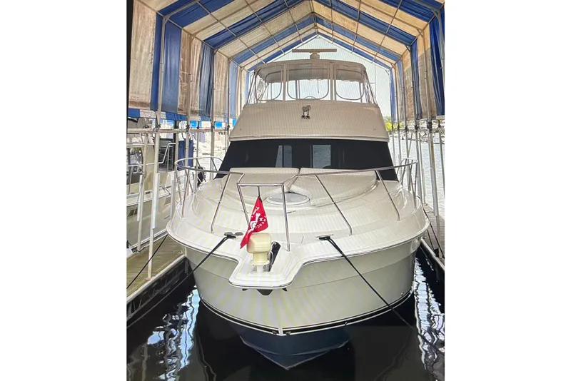The Image of 2005 Silverton 34 Convertible yacht docked under a covered marina. - 0