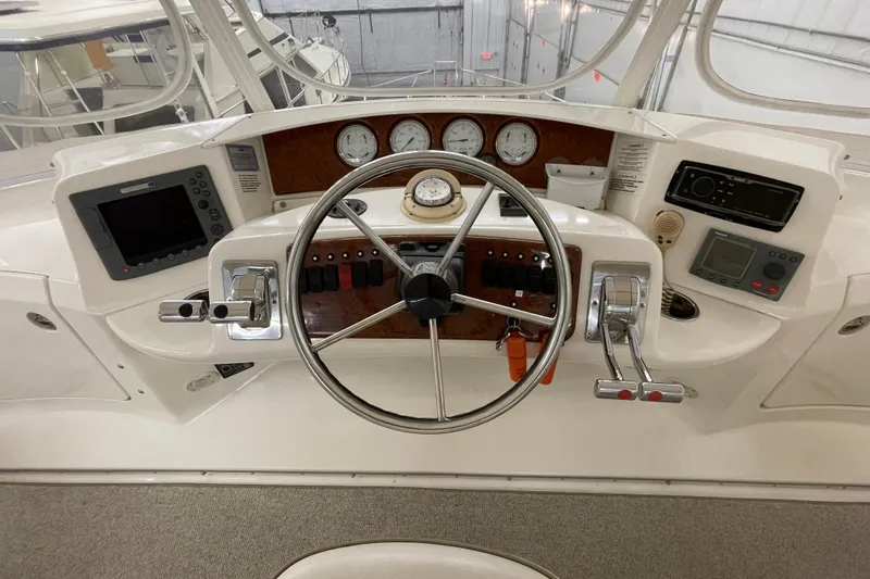 Slide: The Image of 2005 Silverton 34 Convertible helm with steering wheel, gauges, and navigation controls. - 11