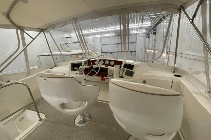 Slide: The Image of 2005 Silverton 34 Convertible yacht interior with helm and seating in a covered area. - 15