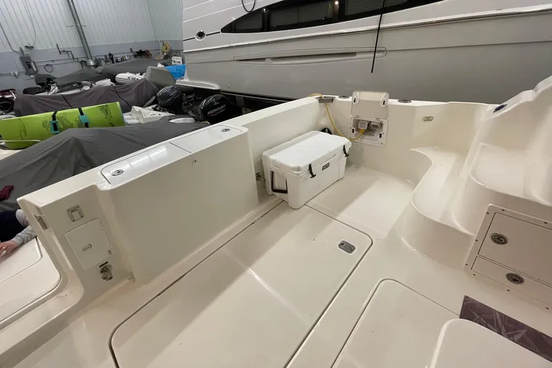 Slide: The Image of 2005 Silverton 34 Convertible boat interior with storage and cooler in a marina setting. - 16