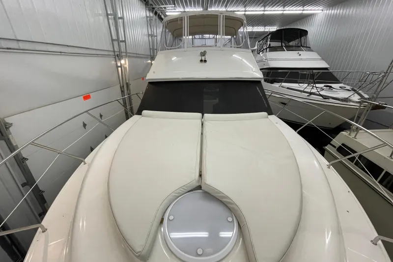 Slide: The Image of 2005 Silverton 34 Convertible yacht in indoor storage, showcasing sleek design and spacious deck. - 21