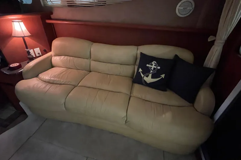 Slide: The Image of Beige leather sofa with nautical-themed pillows in a 2005 Silverton 34 Convertible yacht interior. - 24