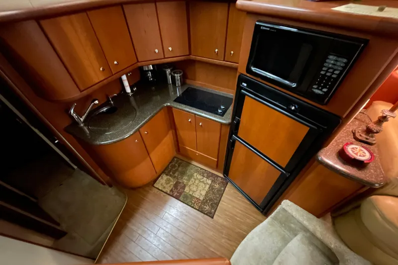 Slide: The Image of 2005 Silverton 34 Convertible yacht kitchen with wood cabinetry, microwave, and compact appliances. - 27