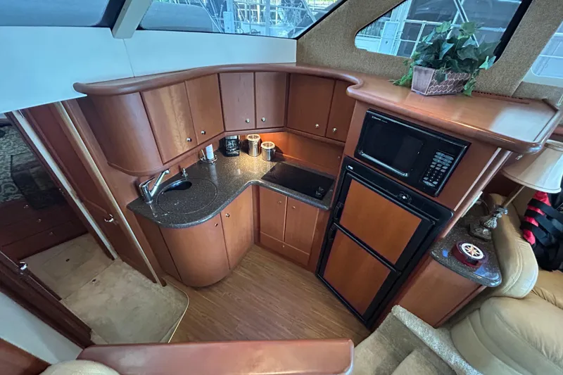 Slide: The Image of Luxurious 2005 Silverton 34 Convertible yacht kitchen with wood cabinetry and modern appliances. - 28