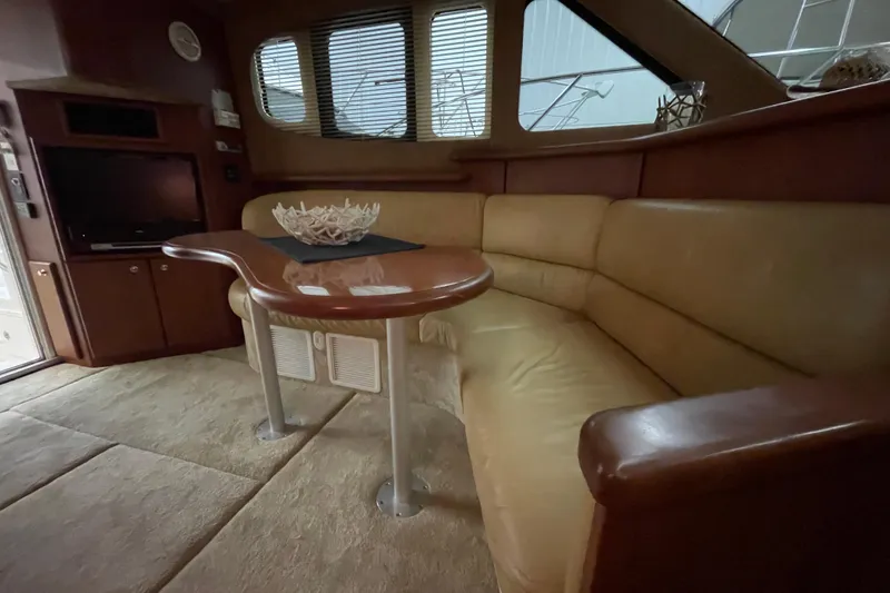 Slide: The Image of Interior of 2005 Silverton 34 Convertible yacht with beige seating and wooden table. - 31