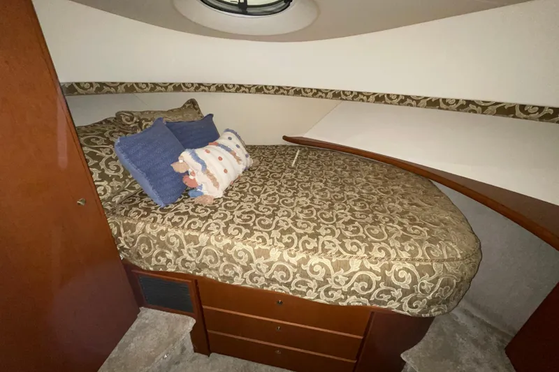 Slide: The Image of Cozy cabin interior of 2005 Silverton 34 Convertible with patterned bedding and decorative pillows. - 34