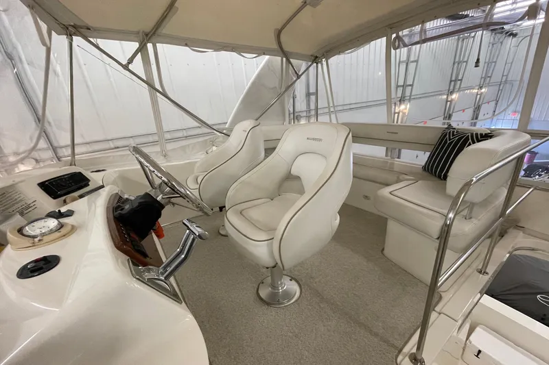 Slide: The Image of 2005 Silverton 34 Convertible yacht interior with white seating and steering console. - 7