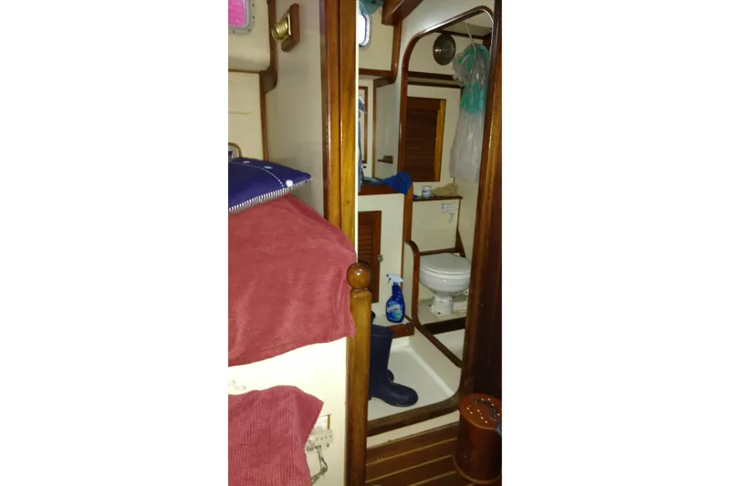 Slide: The Image of Interior of 1990 Bruce Roberts Mauritius Ketch, featuring a compact bathroom and wooden accents. - 10