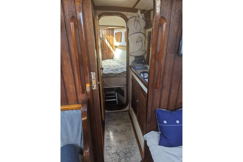 Slide: The Image of Interior of 1990 Bruce Roberts Mauritius Ketch, featuring wooden paneling and cozy cabin space. - 14