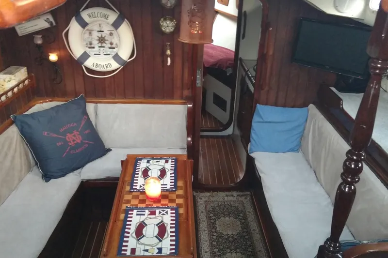 Slide: The Image of Cozy interior of 1990 Bruce Roberts Maurutius Ketch with nautical decor and seating area. - 3