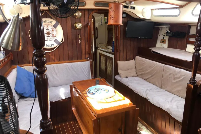 Slide: The Image of Cozy interior of 1990 Bruce Roberts Maurutius Ketch with wooden furnishings and nautical decor. - 4