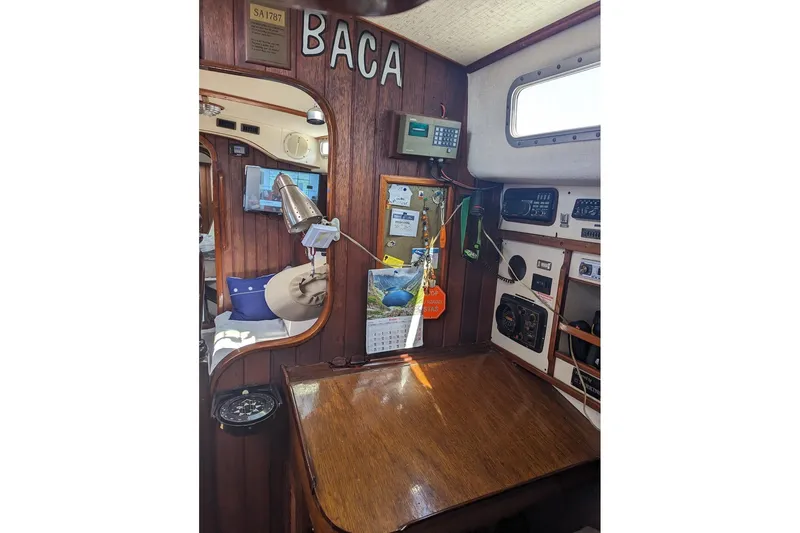 Slide: The Image of Interior of 1990 Bruce Roberts Mauritius Ketch, featuring navigation equipment and wooden furnishings. - 6