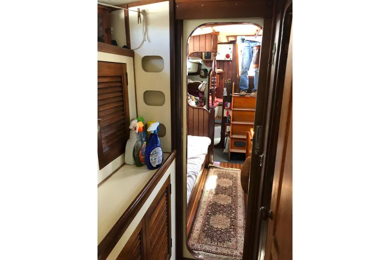 Slide: The Image of Interior of 1990 Bruce Roberts Mauritius Ketch, featuring cozy cabin and wooden furnishings. - 8