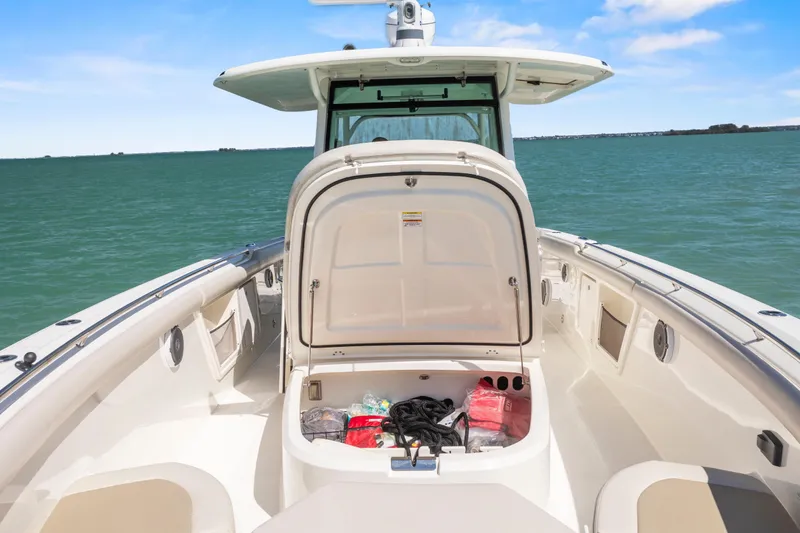 Slide: The Image of 2017 Boston Whaler 350 Outrage boat with open storage compartment on calm water. - 17