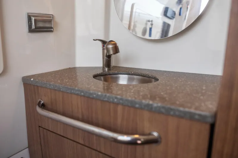 Slide: The Image of 2017 Boston Whaler 350 Outrage bathroom sink with modern faucet and wooden cabinetry. - 40