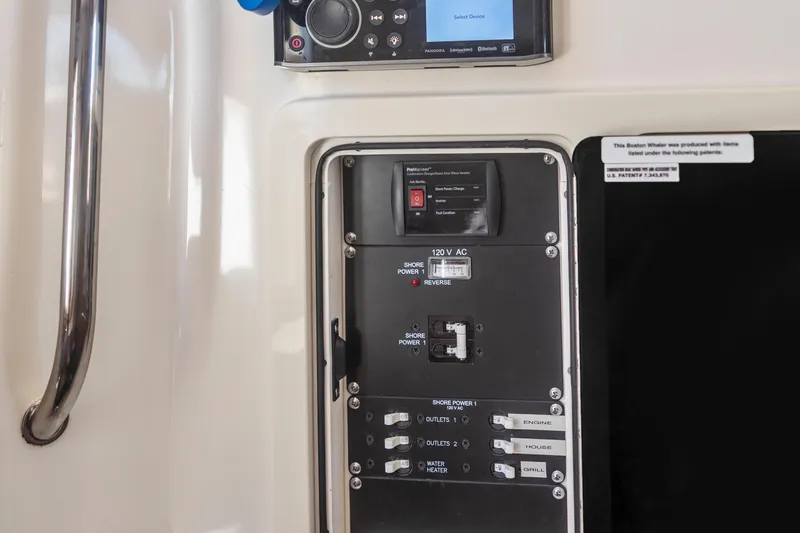 Slide: The Image of Control panel of a 2017 Boston Whaler 350 Outrage boat, featuring electrical switches and display. - 42