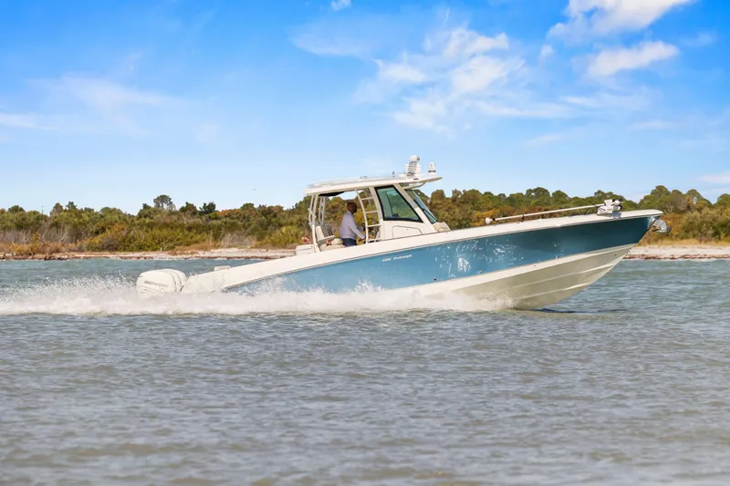 Slide: The Image of 2017 Boston Whaler 350 Outrage cruising on water under clear blue sky. - 50