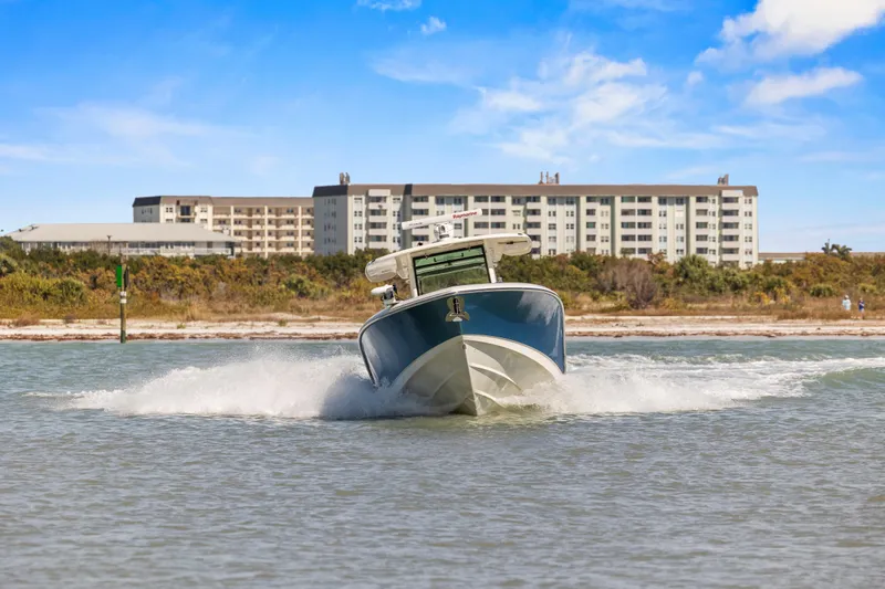 Slide: The Image of 2017 Boston Whaler 350 Outrage cruising in coastal waters with buildings in the background. - 52